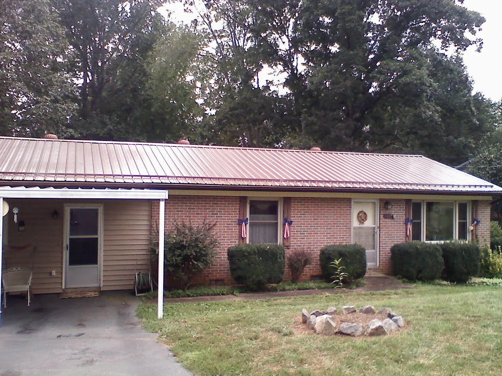 Bronze metal roof and carport on a brick ranch home — Roof Repair work by our crew in Gloversville